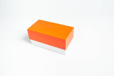 Beyaz arka planda turuncu-kırmızı kutu kapaklı kapalı karton kutu.
