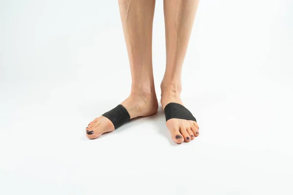 stabilizing orthosis for the correction of the big toe on the woman legs when hallux valgus, 2 legs, close-up isolated, white background