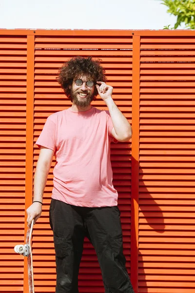 Man with skateboard on red background — Stock Photo, Image