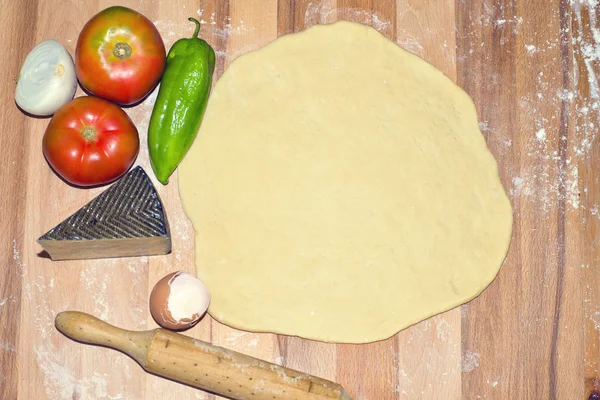 Тесто сырая пицца с вегетарианскими ингредиентами — стоковое фото