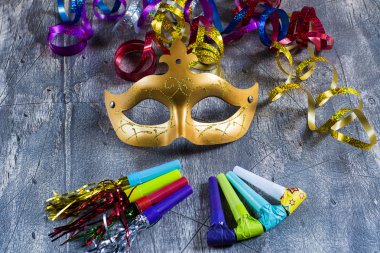 Karnaval maskesi ile renkli flamalar ve parti üfleyiciler