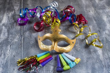 Karnaval maskesi ile renkli flamalar ve parti üfleyiciler