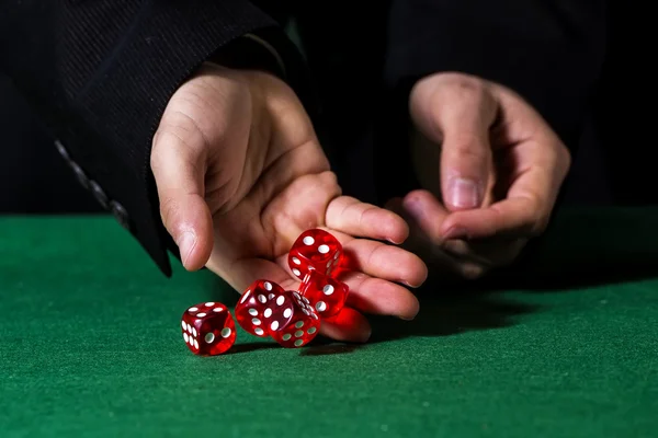 Mano masculina rodando cinco dados en fieltro verde — Foto de Stock