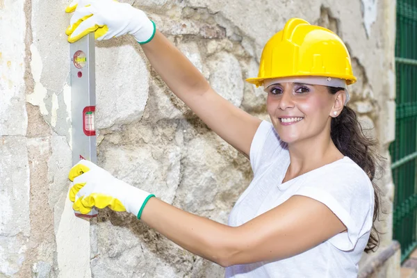 Vrouw met gereedschap niveau in het werk — Stockfoto