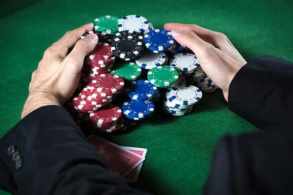 Man verzamelen Casinofiches in de voorgrond — Stockfoto