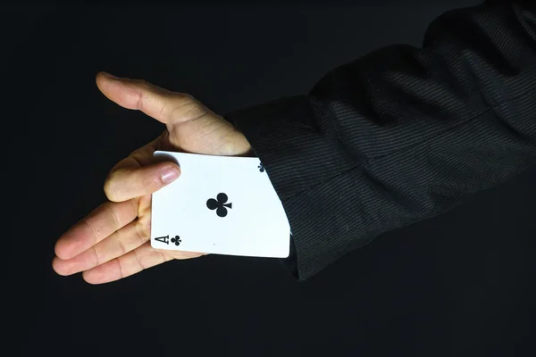 Hombre con as bajo la manga sobre fondo negro — Foto de Stock