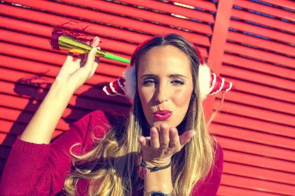 Portrait of woman with earmuffs Christmas; on red background — Stock Photo, Image