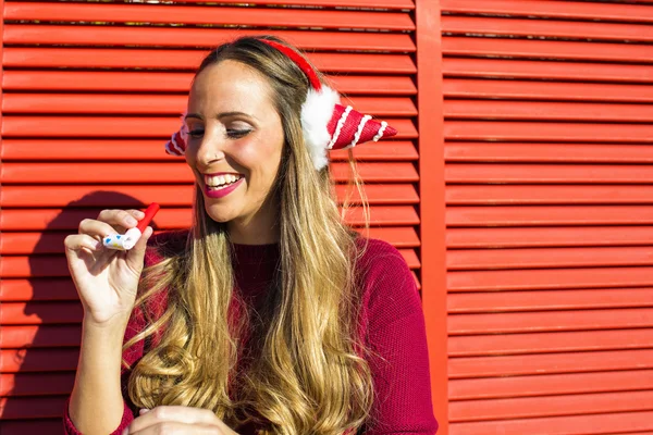 Portrait de femme avec cache-oreilles Noël ; sur fond rouge — Photo