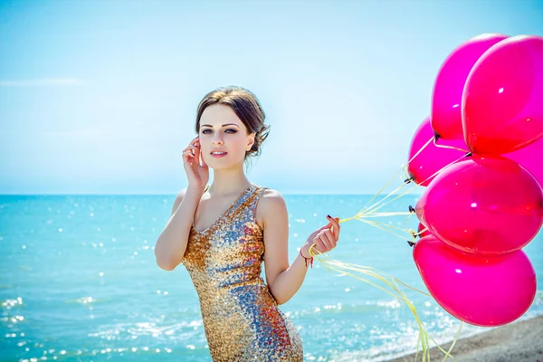 Woman with balloons on the sea — Stock Photo, Image