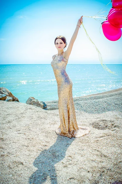 Vrouw met ballonnen op de zee — Stockfoto