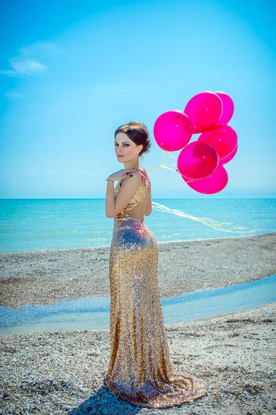 Vrouw met ballonnen op de zee — Stockfoto