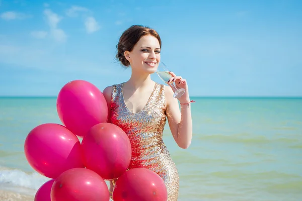 Vrouw met ballonnen op de zee — Stockfoto