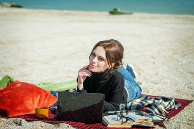 genç kadının çalışmasını sahilde