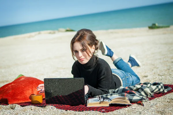 Junge Frau genießt ihre Arbeit am Strand — Stockfoto