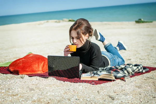 Junge Frau genießt ihre Arbeit am Strand — Stockfoto