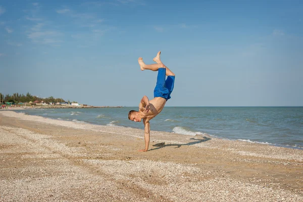 Genç adam sahilde atlama — Stok fotoğraf