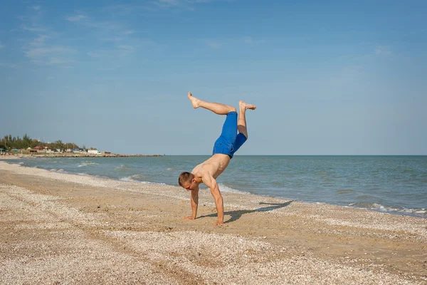 Junger Mann springt am Strand — Stockfoto