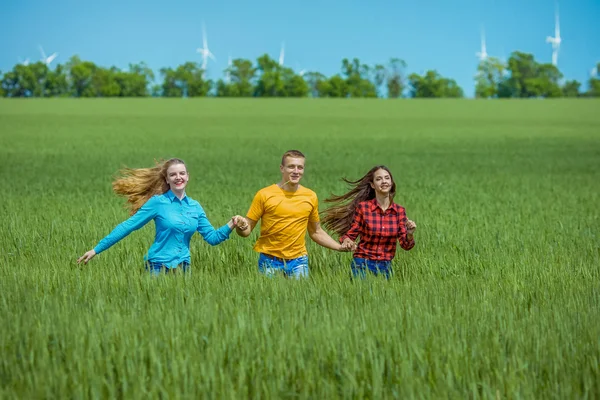 Jovens felizes Amigos correndo no campo de trigo verde — Fotografia de Stock
