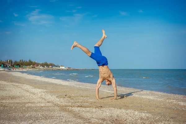Young man jumping on beach — Stock Photo, Image