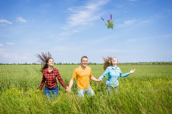 Jeunes amis heureux fonctionnant sur le champ de blé vert — Photo
