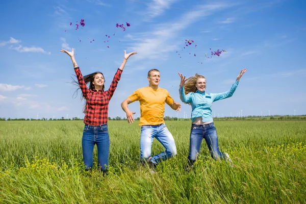 Unga glada vänner kör på grön vete fält — Stockfoto