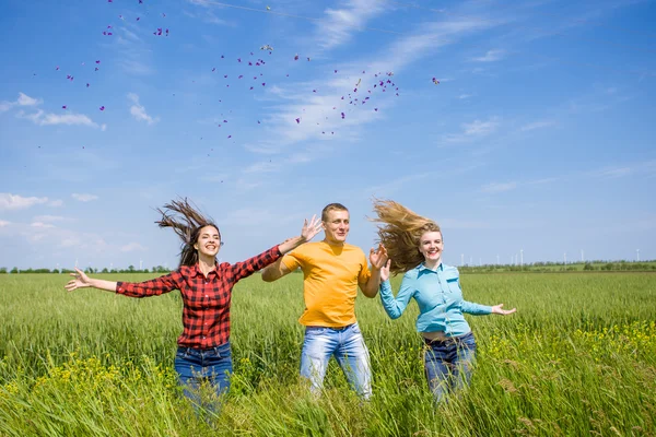 Jeunes amis heureux fonctionnant sur le champ de blé vert — Photo