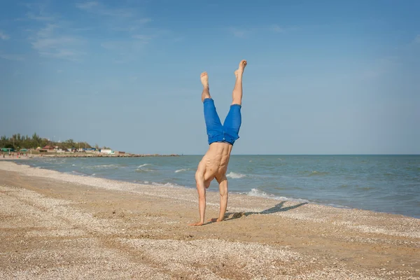 若い男がビーチにジャンプ — ストック写真