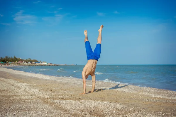 Junger Mann springt am Strand — Stockfoto