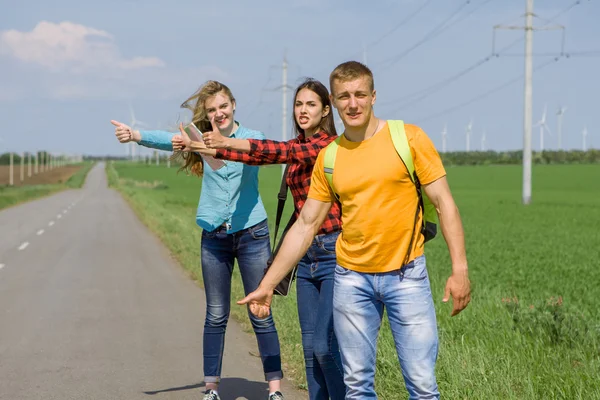 Giovani amici hipster viaggiano su strada — Foto Stock