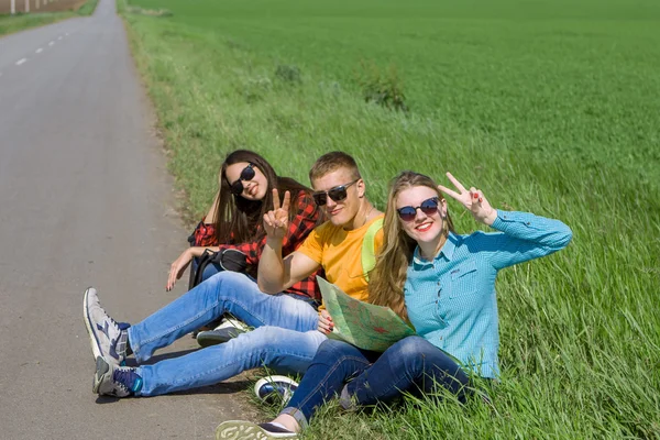Giovani amici hipster viaggiano su strada — Foto Stock