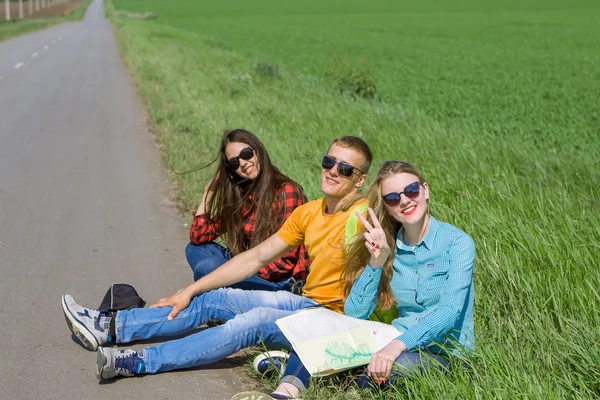 Giovani amici hipster viaggiano su strada — Foto Stock