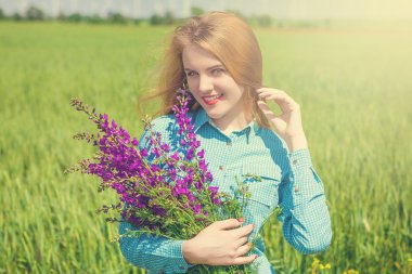 Kır çiçekleri ile sahada güzel kız