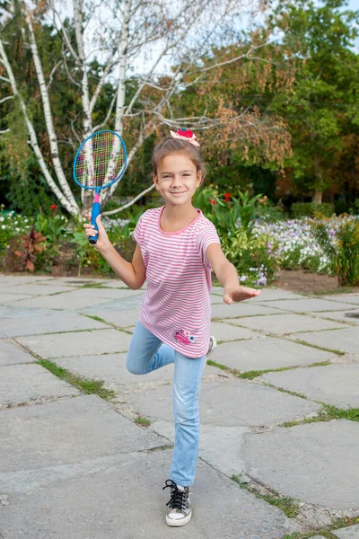 Menina bonito com raquete ao ar livre — Fotografia de Stock