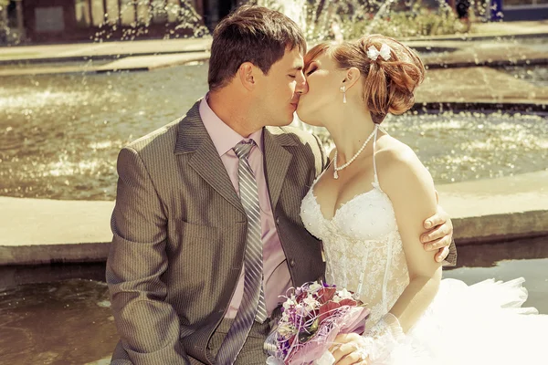 Bruid en bruidegom zacht kussen — Stockfoto