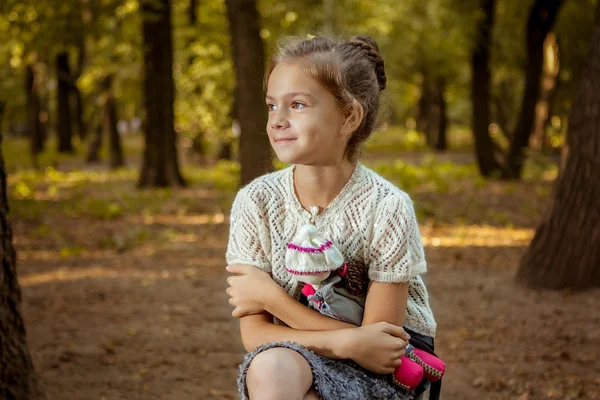 Charming little girl in forest with  doll — Stock Photo, Image