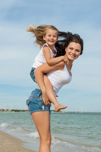 Moeder en haar dochter plezier op het strand — Stockfoto