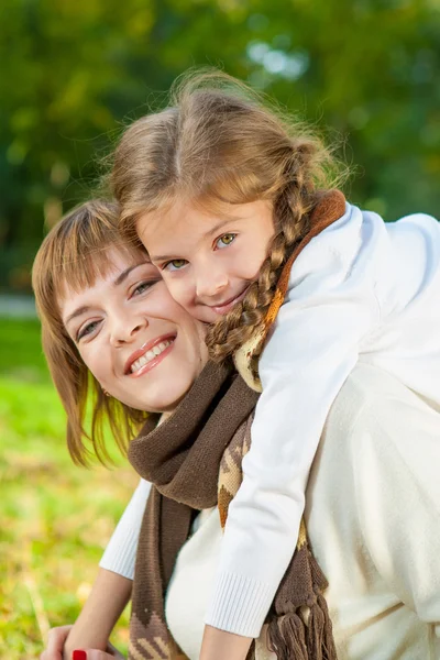 Glad mamma med lilla dotter i höst park Royaltyfria Stockbilder