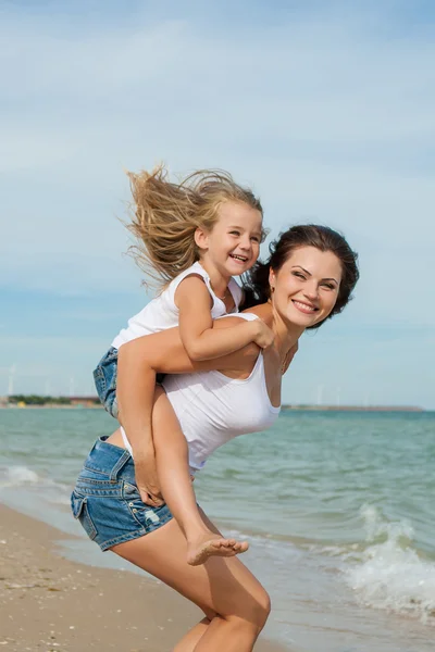 Madre y su hija se divierten en la playa —  Fotos de Stock