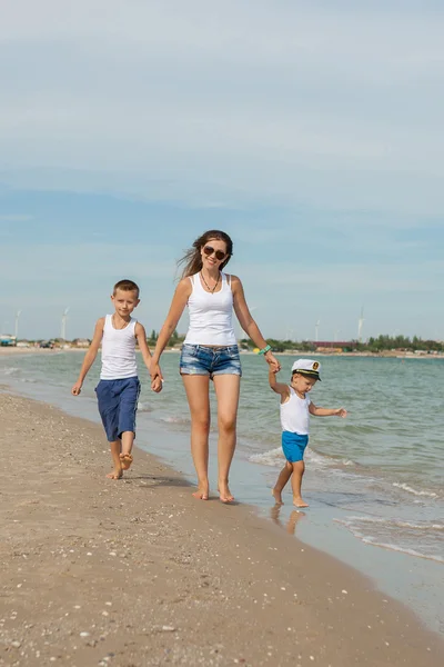 Mãe e seus dois filhos se divertindo na praia — Fotografia de Stock