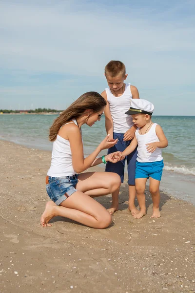 Matka i jej dwóch synów, zabawy na plaży — Zdjęcie stockowe