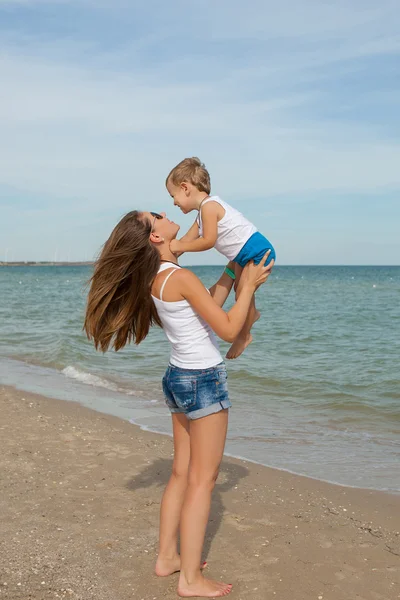 Moeder en haar zoon plezier op het strand — Stockfoto