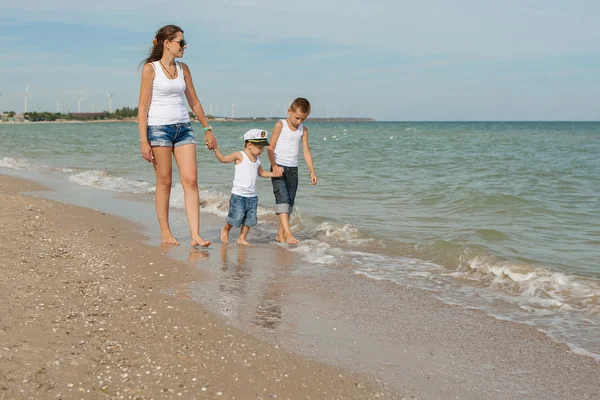 Mãe e seus dois filhos se divertindo na praia — Fotografia de Stock