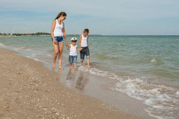 Mãe e seus dois filhos se divertindo na praia — Fotografia de Stock