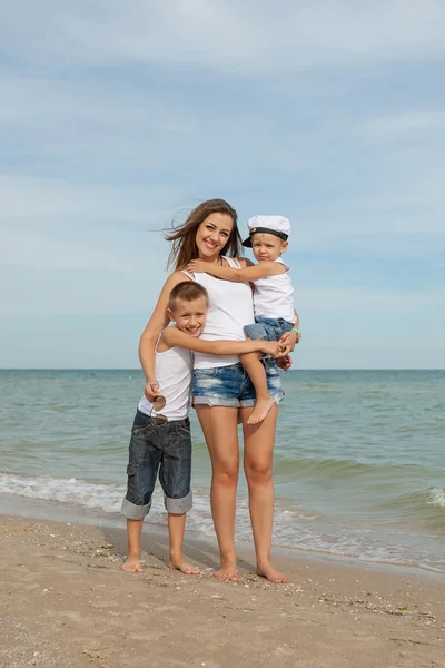 Mutter und ihre beiden Söhne amüsieren sich am Strand — Stockfoto