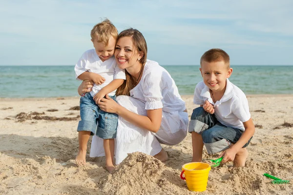 Mutter und ihre beiden Söhne amüsieren sich am Strand — Stockfoto