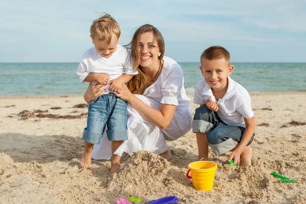 Moeder en haar twee zoons plezier op het strand — Stockfoto