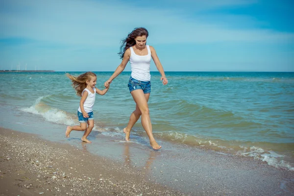 Gelukkig mooie moeder en dochter genietend van strand tijd — Stockfoto