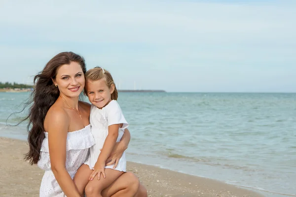 Feliz hermosa madre e hija disfrutando del tiempo de playa —  Fotos de Stock