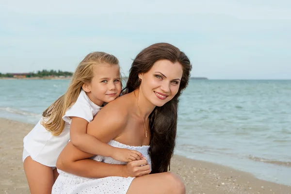 Happy beautiful mother and daughter enjoying beach time — Stock Photo, Image