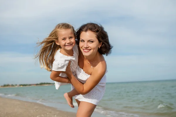 Happy beautiful mother and daughter enjoying beach time — Stock Photo, Image